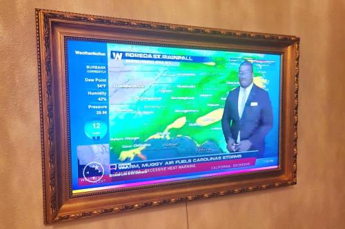 a picture of a tv screen with a man on it at Polynesian Koi Pond Gardens Condo in Hilo w pool in Hilo