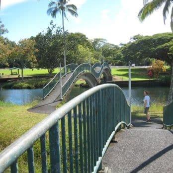a boy is looking at a playground in a park at Polynesian Koi Pond Gardens Condo in Hilo w pool in Hilo