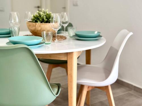 a dining room table with a white table and chairs at El sueño de mi vida in Caleta De Fuste