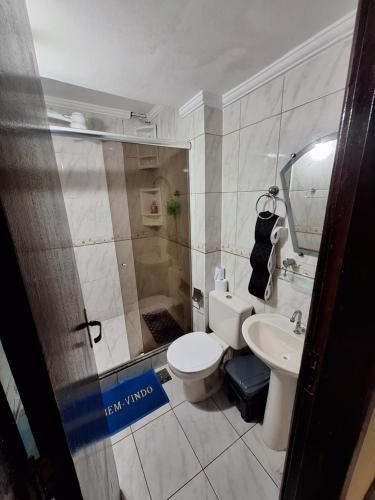 a bathroom with a toilet and a sink at Quartos da lagoa in Cabo Frio