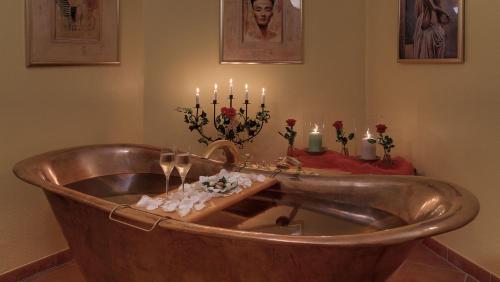 eine Kupferbadewanne mit Kerzen und einen Tisch mit Rosen in der Unterkunft Der Romantik-Hof Greetsiel in Greetsiel