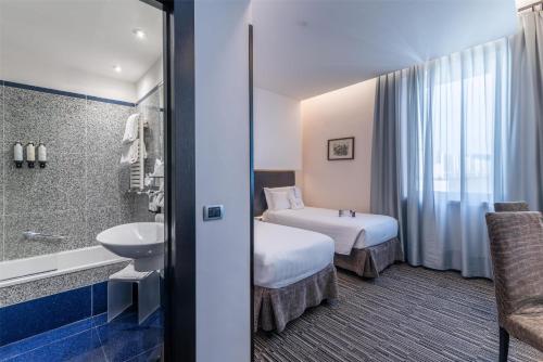 a hotel room with two beds and a bathroom at Best Western Plus Hotel Universo in Rome