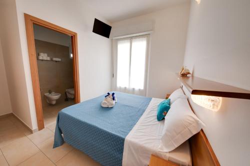 una camera da letto con un letto su cui ci sono due animali di peluche di Hotel Numi a Rimini
