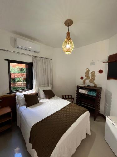 a bedroom with a large bed and a window at Pousada Buriti in Itaúnas