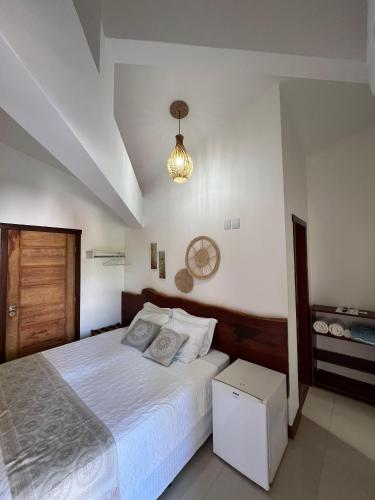 a bedroom with a bed and a clock on the wall at Pousada Buriti in Itaúnas