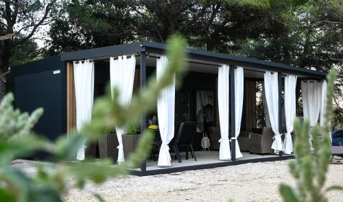 a black and white shed with white curtains at Mobile home Periska, Pakoštane in Pakoštane
