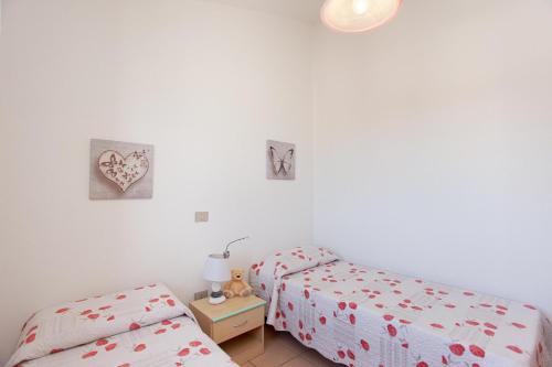 two beds in a room with white walls at Prenda Home Holiday in Posada