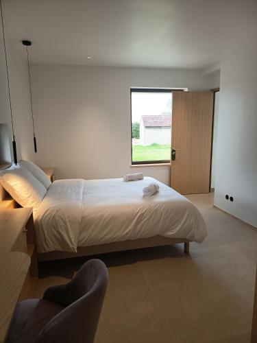 a bedroom with a large bed and a window at Les Hôtes des Maillets 