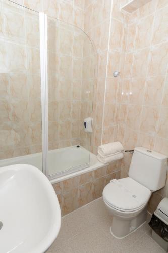 a bathroom with a toilet and a shower and a tub at Hacienda Guadalquivir in Córdoba