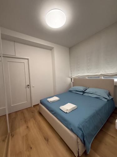 a bedroom with a bed with blue sheets and a white door at GORGHI House in Udine