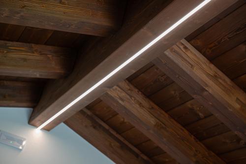 a metal beam in a wooden ceiling with a light at Paverno Suites in Marano di Valpolicella
