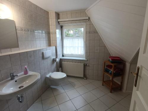 a bathroom with a sink toilet and a window at Reethäuser auf Rügen in Middelhagen