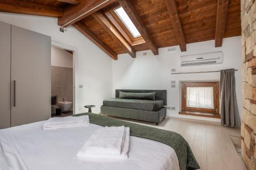 a bedroom with a bed and a couch at Paverno Suites in Marano di Valpolicella