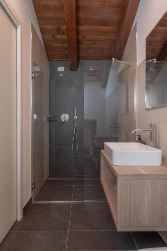 a bathroom with a shower and a sink and a tub at Paverno Suites in Marano di Valpolicella