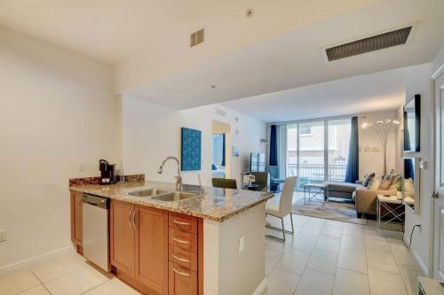a kitchen with a sink and a living room at Amazing one-bedroom in Casa Costa!BEACH PASS INC! in Boynton Beach