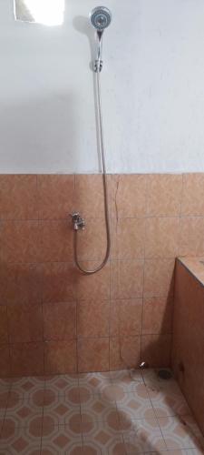 a shower with a shower head in a bathroom at Bunaken Jhon Homestay in Manado