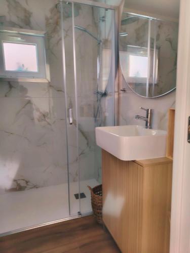a bathroom with a sink and a shower with a mirror at Casa d'Arcã in Alijó