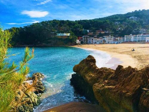 Blick auf einen Strand mit Gebäuden im Hintergrund in der Unterkunft Impresionantes Vistas Mar en el centro de Begur in Begur