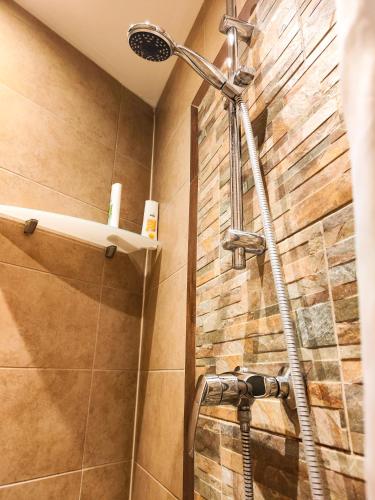 eine Dusche in einem Badezimmer mit einer Steinwand in der Unterkunft The Smart Flat in Wien