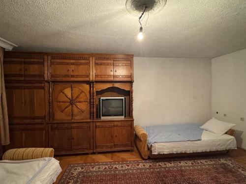 a bedroom with a bed and a tv in a room at Drenis Home in Prizren