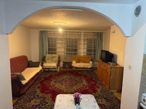 a living room with a couch and a tv at Drenis Home in Prizren