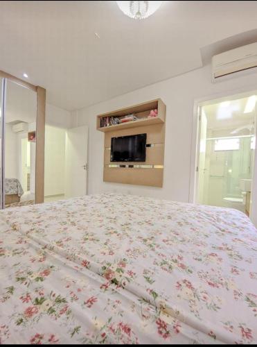 a bedroom with a large bed with a floral bedspread at APARTAMENTO cop30 in Belém