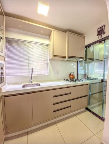 a kitchen with white cabinets and a sink at APARTAMENTO cop30 in Belém