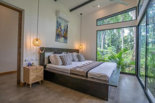 a bedroom with a large bed and a large window at Anusara Dream Villa with Pool & AC in Talamanca