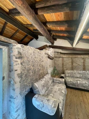 a living room with a couch and a stone wall at ALBERGO DIFFUSO ORNICA NEL CUORE in Ornica
