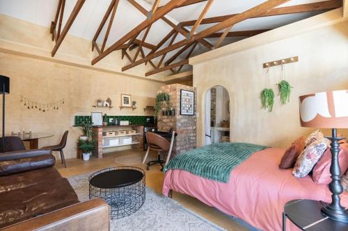 Un dormitorio con una cama y una sala de estar. en Bohemian Private Flat, Aircon, Secure Parking, en Stellenbosch