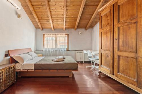 ein Schlafzimmer mit einem Bett und einer Holzdecke in der Unterkunft Ampia casa su due piani, a pochi minuti dai Navigli e metro in Mailand