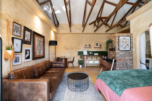 Una sala de estar con un sofá de cuero marrón y una mesa. en Bohemian Private Flat, Aircon, Secure Parking, en Stellenbosch