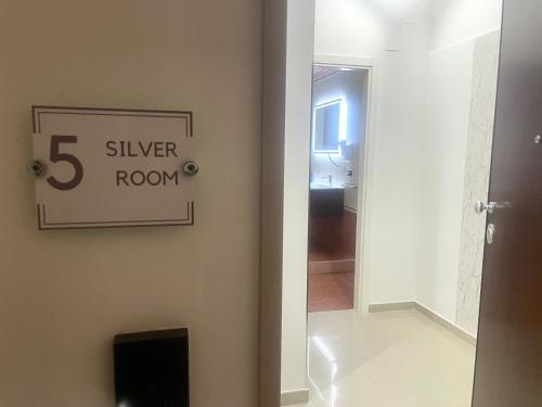 a bathroom with a silver room sign on the wall at B&B CORSO ROMA Room Suite & Spa in Apricena