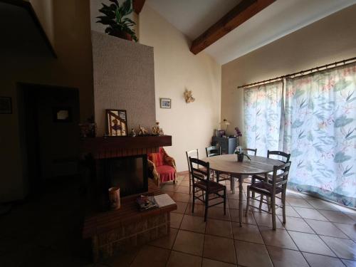 une salle à manger avec une table et des chaises et une cheminée dans l'établissement Chambre vue jardin rez-de-chaussée, à Millas