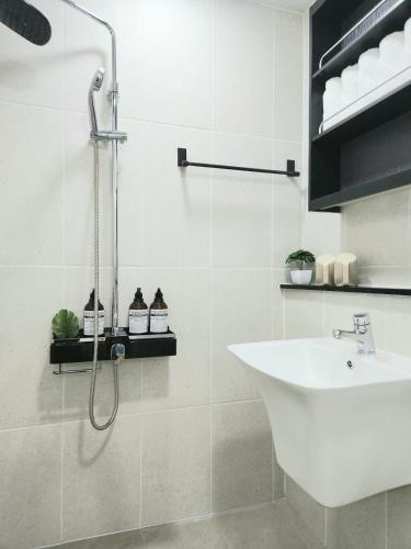 a white bathroom with a shower and a sink at Gonghangdong Every moment in Seoul