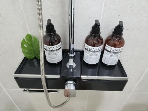 three bottles of shampoo on a shelf in a bathroom at Gonghangdong Every moment in Seoul