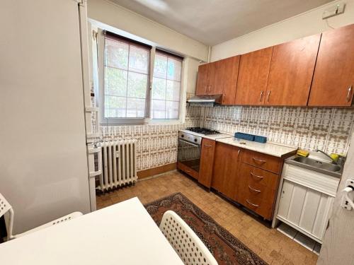 a kitchen with wooden cabinets and a table in it at Dni apartment in Bucharest