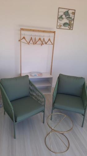 two green chairs and a table in a room at Parthenope in Petacciato