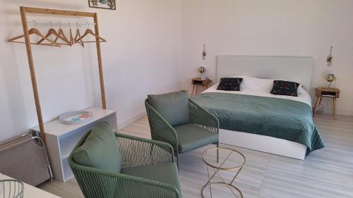 a bedroom with a bed and chairs in a room at Parthenope in Petacciato