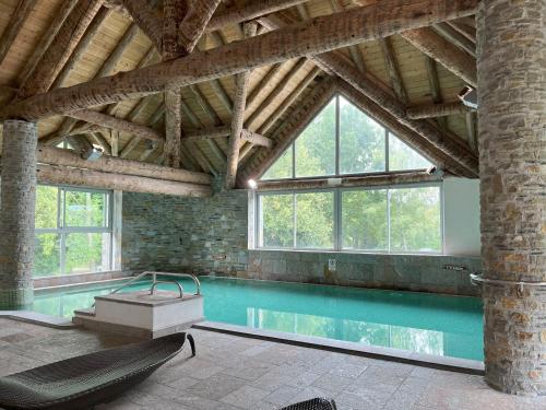 Vielle-AureにあるDomaine des Ardoisières - 2-4 persの大きな天井と窓のある屋内スイミングプールを提供しています。
