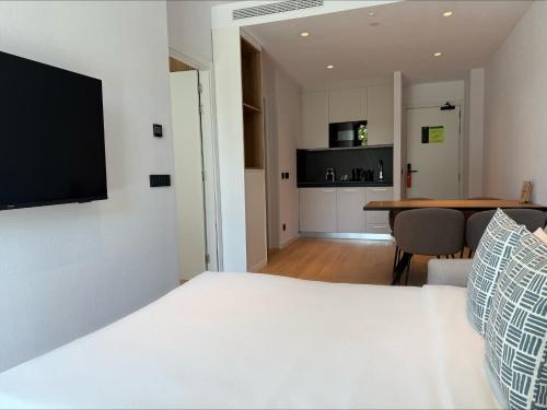 a bedroom with a bed and a kitchen with a table at Tembo Barcelona in Barcelona