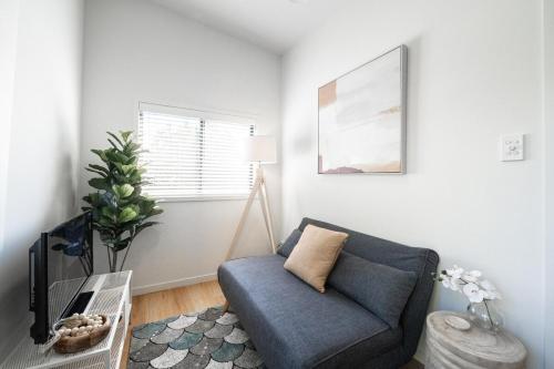 a living room with a blue couch and a table at Tiny Home 1BD, 1BA in Clayfield, Near Brisbane CBD M2 in Brisbane