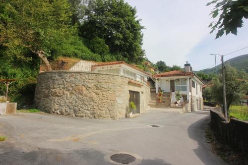 a stone wall in front of a house at Casa da Idalina in Terras de Bouro