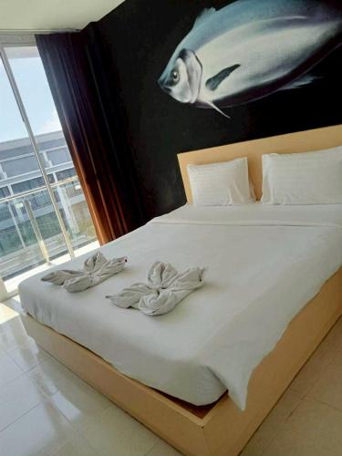 a bedroom with a bed with a fish painting on the wall at XX GO Inn Krabi Aonang Beach - โกอินน์ อ่าวนาง in Ban Khlong Haeng