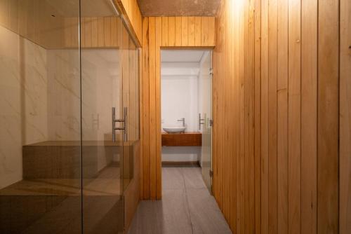 a bathroom with a glass door leading to a sink at Casa de Lujo Frente al Mar - Chacra Lobos de Mar in Nueva Atlantis