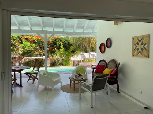 a living room with chairs and a pool at La Maison MaHogany in Saint-François