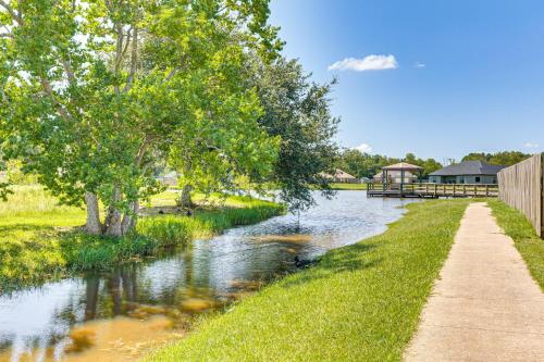 a path next to a river with a house in the background at Suburban Bliss! Cozy Home with Neighborhood Perks in Theodore