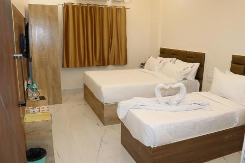a hotel room with two beds with white sheets at Hotel jetway in Muthugadahalli