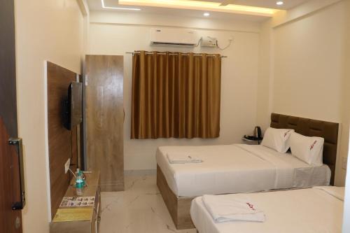 a hotel room with two beds and a television at Hotel jetway in Muthugadahalli