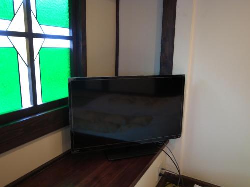 a flat screen tv sitting in front of a window at Minshuku Takizawa in Takayama